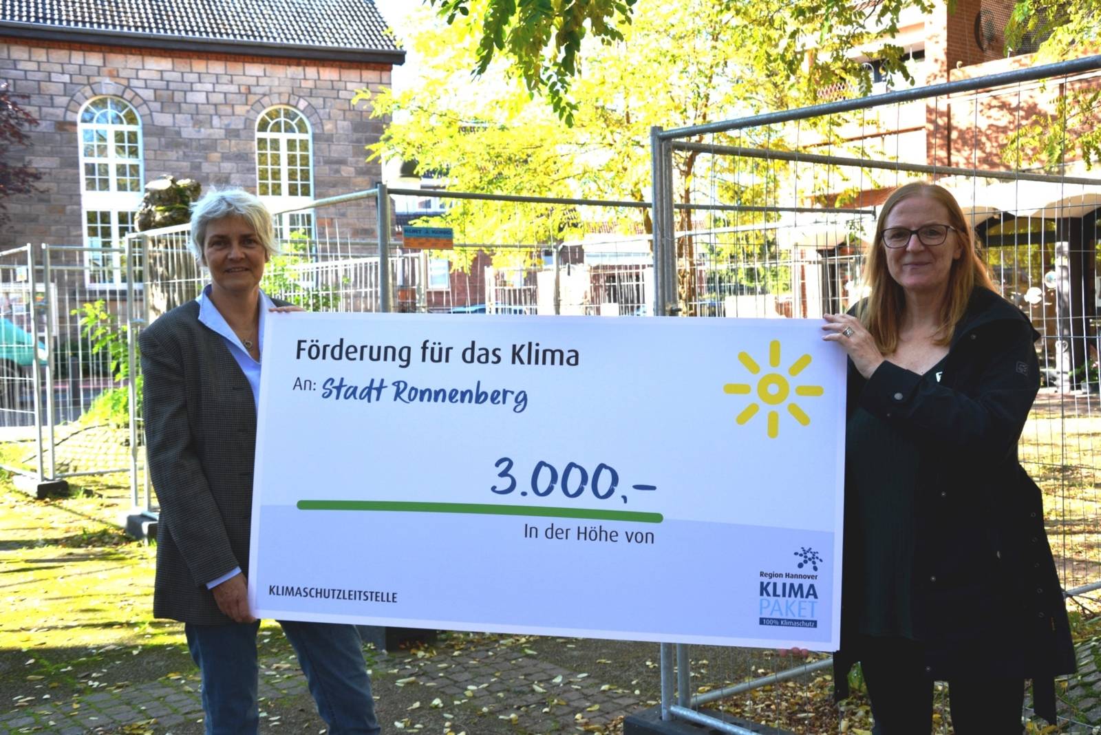 Zwei Frauen, die ein Plakat halten, auf dem steht: Förderung für das Klima - An Stadt Ronnenberg - Betrag: 3000 Euro